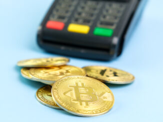 Bitcoin coins near POS payment terminal on the blue background. Crypto currency for payment