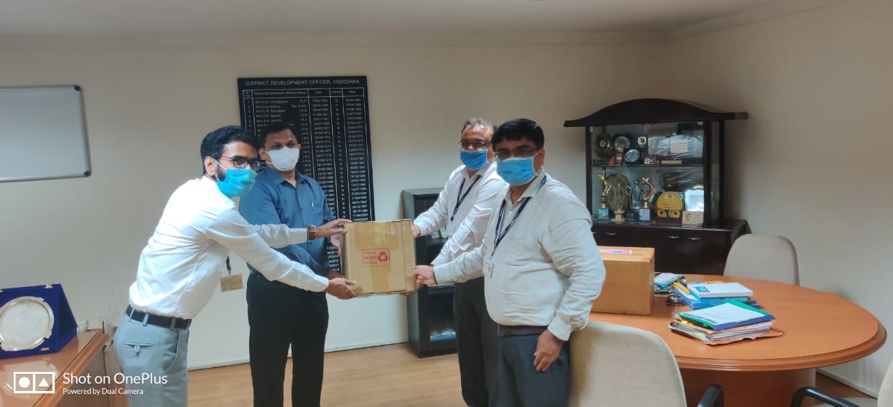 ICICI Bank officials handing over protective equipment to senior government official in Vadodara.